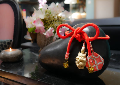 A black bronze urn in the shape of a pebble with a small cat charm